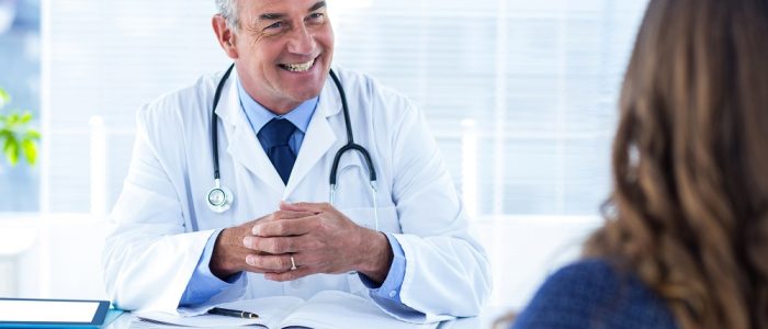 Smiling male doctor with woman in clinic