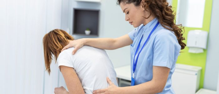 physiotherapist-doing-healing-treatment-womans-back-back-pain-patient-treatment-medical-doctor-massage-therapistoffice-syndrome