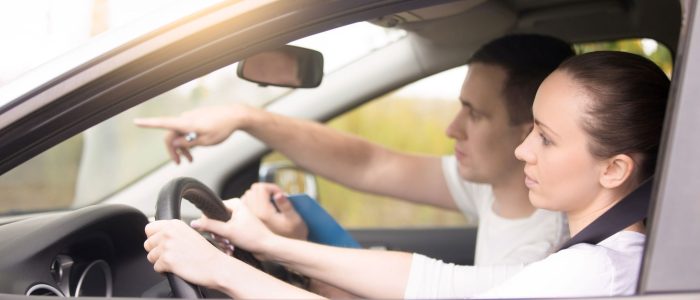 young-woman-driving-man-pointing-direction
